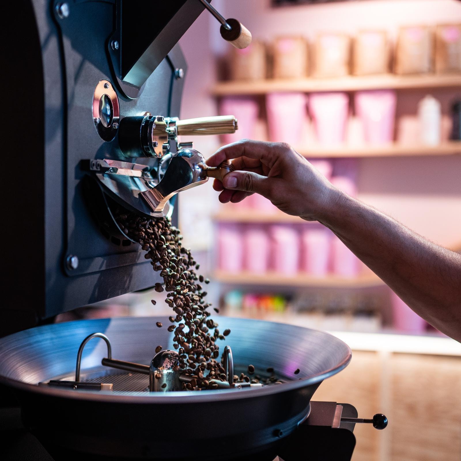 Barista operating a coffee roaster at a Pittsburgh specialty café