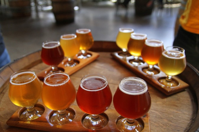 Craft beer flight on a barrel — multiple styles and colors