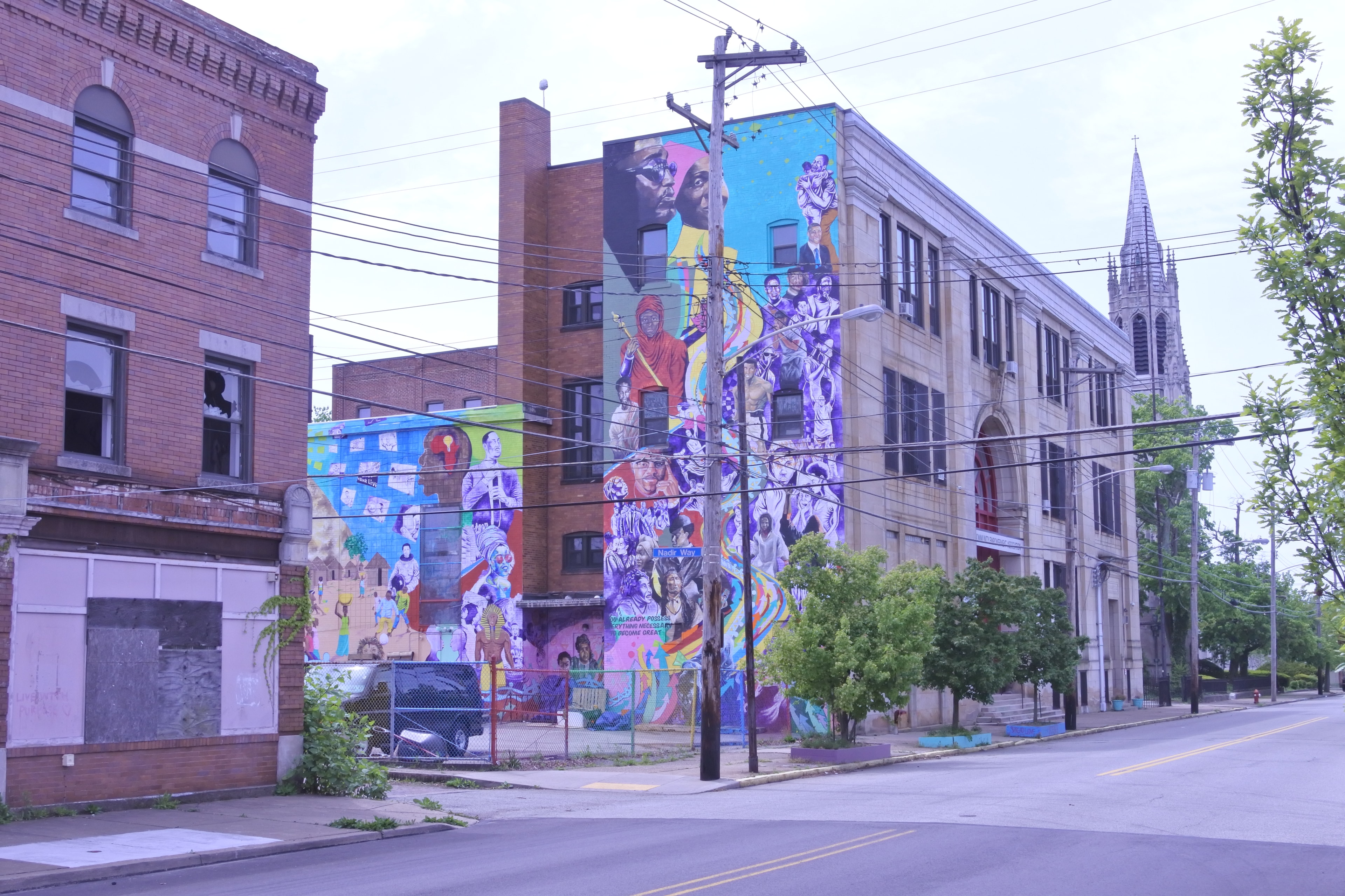 Vibrant community mural on brick buildings in Homewood, Pittsburgh