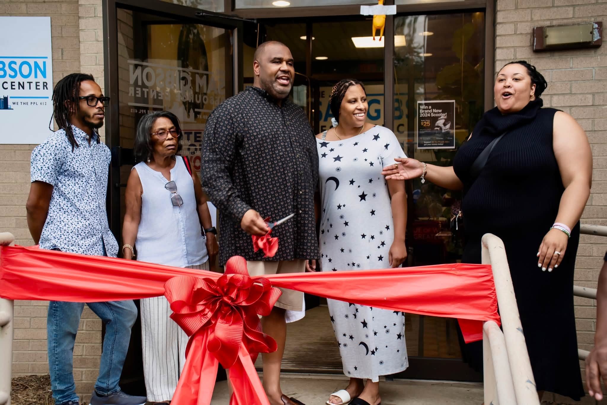 Sam Gibson and community members at the grand opening ribbon cutting of the We The Ppl 412 Resource Center in Homewood