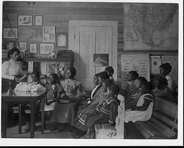 Historic photograph of Black students and teacher in a segregated classroom, early 20th century
