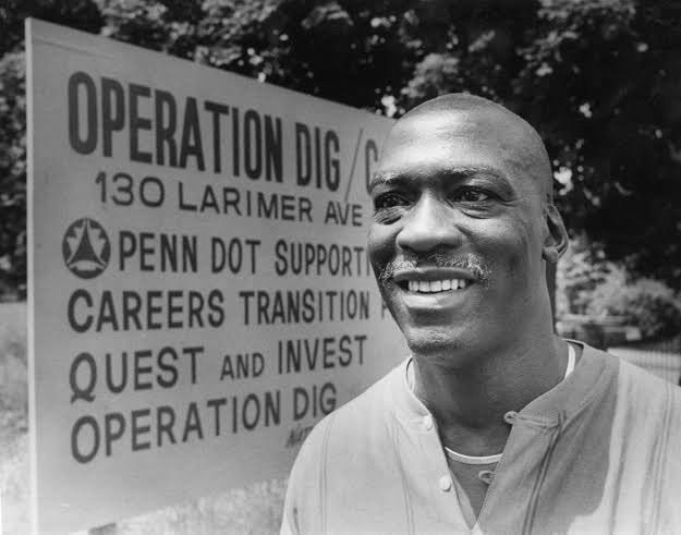 Nate Smith standing in front of the Operation Dig sign at 130 Larimer Ave, Pittsburgh