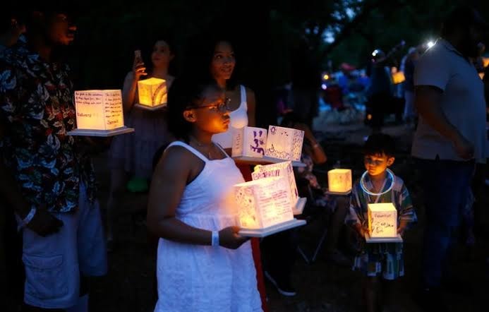 Families including children holding glowing personalized lanterns before the evening release